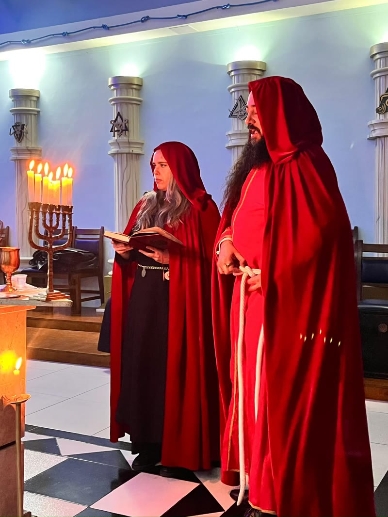 Oficiantes da Ordem em leitura ritual, à luz das velas